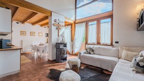 Un amplio espacio de estar con un sofá, una chimenea y una mesa de comedor.