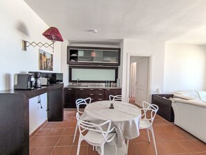 Un espacio habitable compacto con kitchenette, comedor y cama.