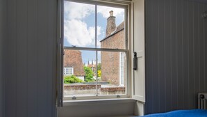 Ein Schlafzimmer mit Fenster, Bett und Heizkörper.