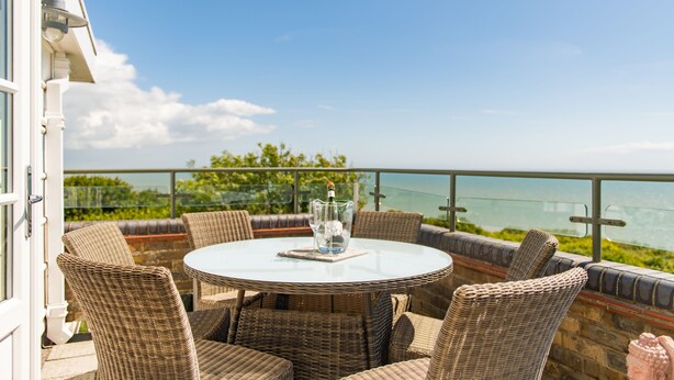 A round table with wicker chairs on a balcony overlooking a body of water. - Pip's Lookout, St Margaret's Bay (St Margaret's Bay)