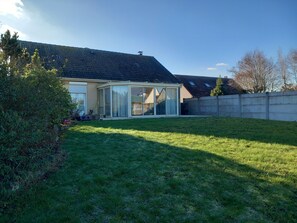 A house with a large glass door leading to a covered patio area.