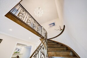 A spiral staircase with ornate metal railings and wooden steps.