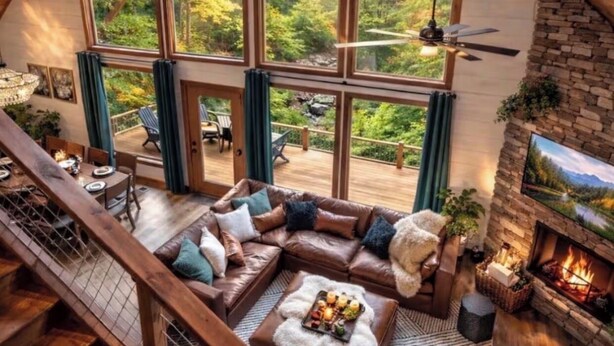 Amplio espacio tipo loft con un gran ventanal con vistas a un bosque, chimenea y zona de comedor.