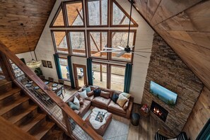 Ein geräumiges Loft mit großem Fenster, Kamin und Treppe.