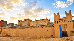 Un edificio grande e histórico con múltiples torres y un muro fortificado.