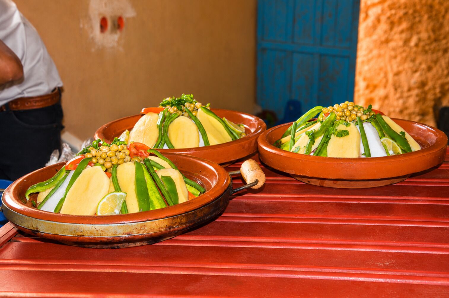 A traditional Moroccan tagine dish on a red table.