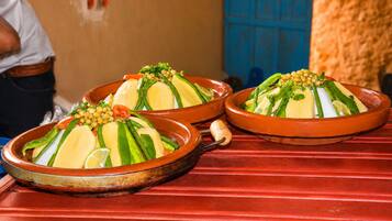 A traditional Moroccan tagine dish on a red table.