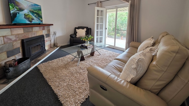 A living room with a fireplace, a sofa, a coffee table, and a television.