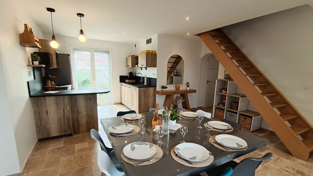 A modern kitchen with a dining area, wooden staircase, and a view of the outdoors. - Beautiful villa with a pool—sleeps 8—Sérignan (Sérignan)