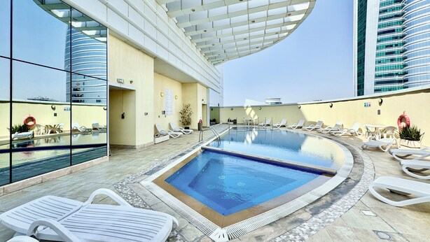 Piscina no terraço com espreguiçadeiras, área envidraçada e arquitetura moderna.