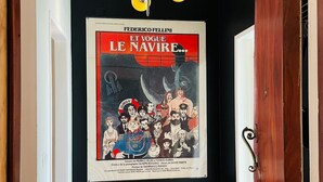 A hallway with a black wall, a wooden floor, and a poster of 'Et Vogue Le Navire' on the wall. - Bright and spacious, just 20 meters from the subway station in a family-friendly neighborhood. (Lisboa)