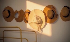 Eine Reihe von Hüten, die an einer Wand hängen.