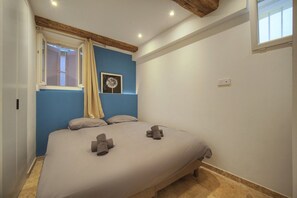 A bedroom with a bed, a window with curtains, a wall clock, and a small picture. - One-bedroom apartment in Cannes, France (Cannes)