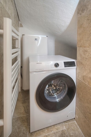 A compact laundry area with a front-loading washing machine and a white dryer. - One-bedroom apartment in France, Cannes (Cannes)