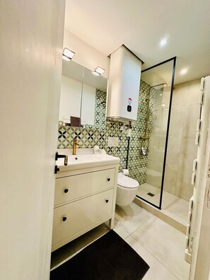 Ein Badezimmer mit Toilette, Waschbecken und Dusche.