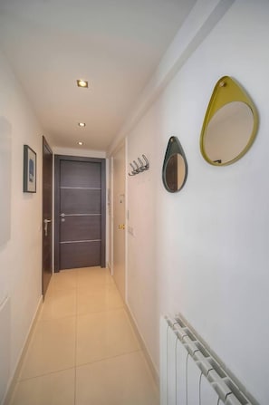 A hallway with a door, a radiator, and wall-mounted mirrors. - 15099954 `Palm Beach Luxury 1-Bedroom Apartment with Balcony, AC` (Cannes)