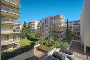 En flervåningsbyggnad med bostäder, balkonger, en liten innergård och en parkeringsplats.
