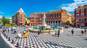 A public square with a fountain, checkered pavement, and historic buildings. - 15014938 FRGK GOUNOD Studio Modern AC Wi-Fi Fiber (Nice)