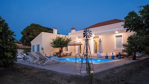 A house with a swimming pool, lounge chairs, and a windmill. - Beachfront, Pool, Chic- Live in Style: Pyrgo Villa (Ialisos)
