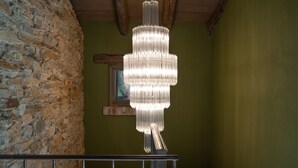 Un candelabro cuelga del techo en una habitación con paredes de piedra y una viga de madera.
