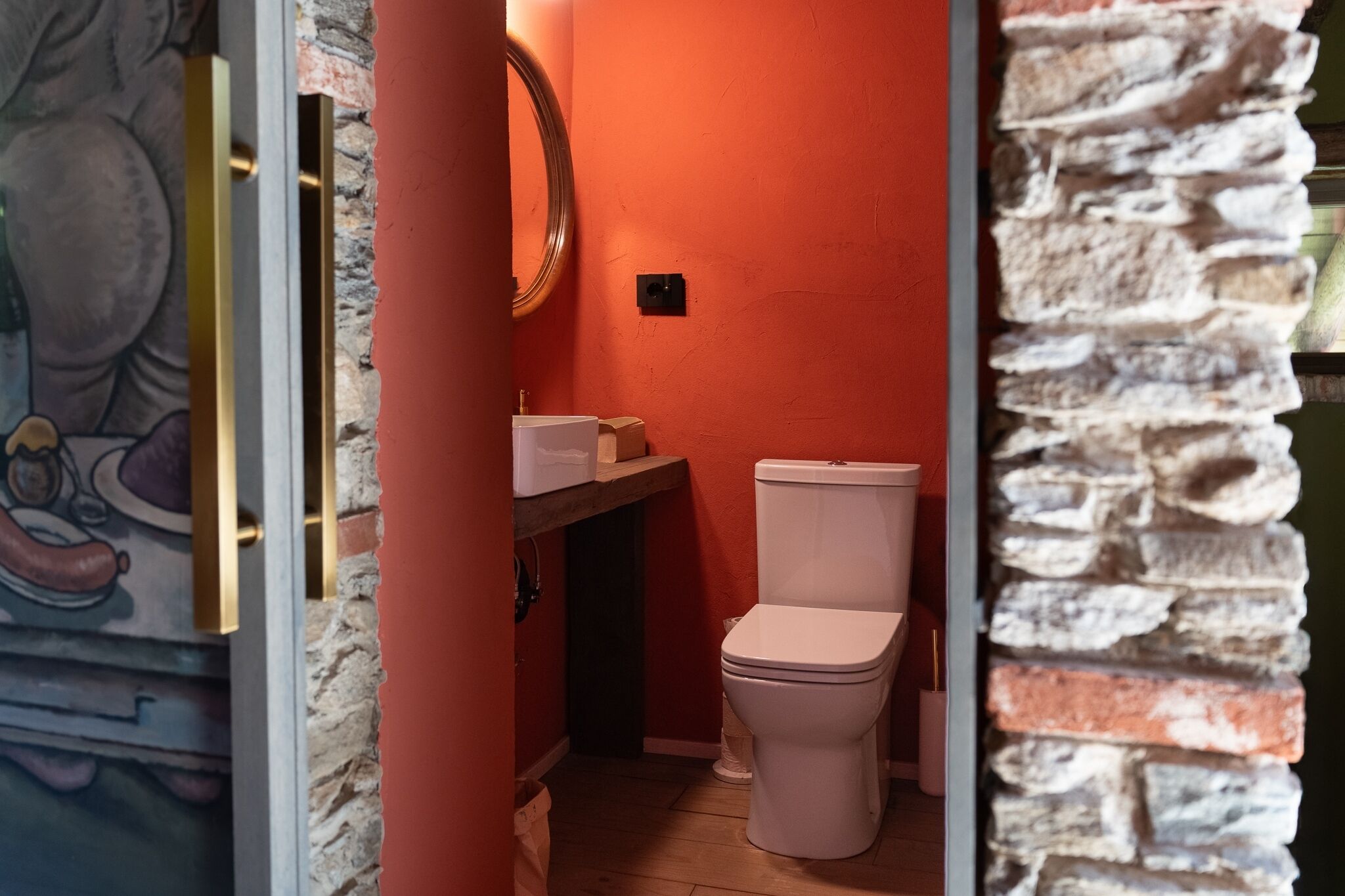 A bathroom with a toilet, a sink, and a mirror.