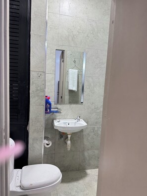 Ein Badezimmer mit Toilette, Waschbecken und Spiegel.