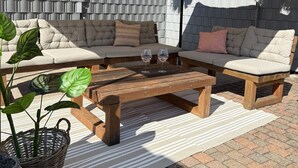 An outdoor seating area with a sofa set, a wooden coffee table, and a canopy. - Carolingian Stay (Emmerich am Rhein)