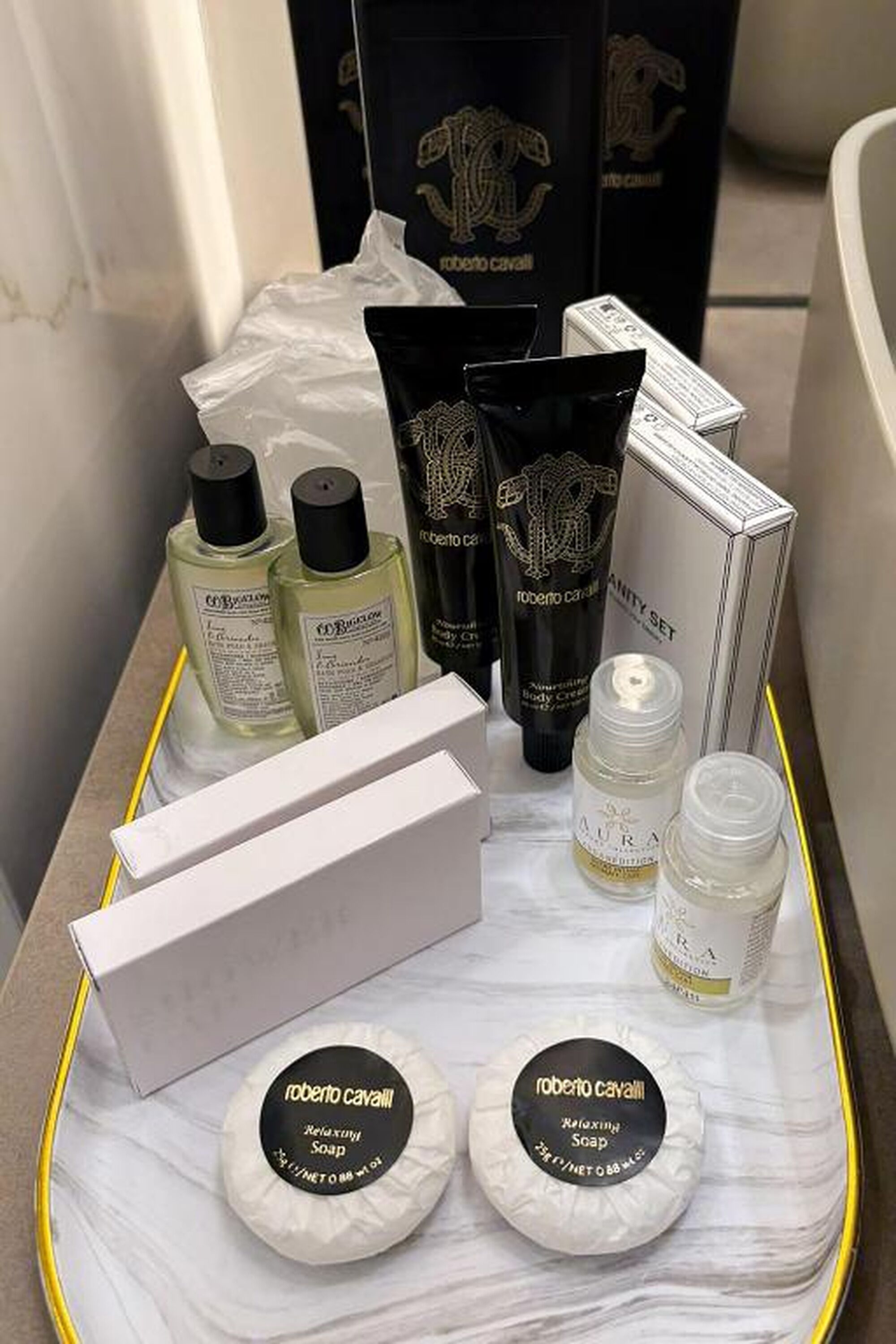 Un vassoio con diversi prodotti Roberto Cavalli, tra cui crema corpo, detergente corpo e sapone.