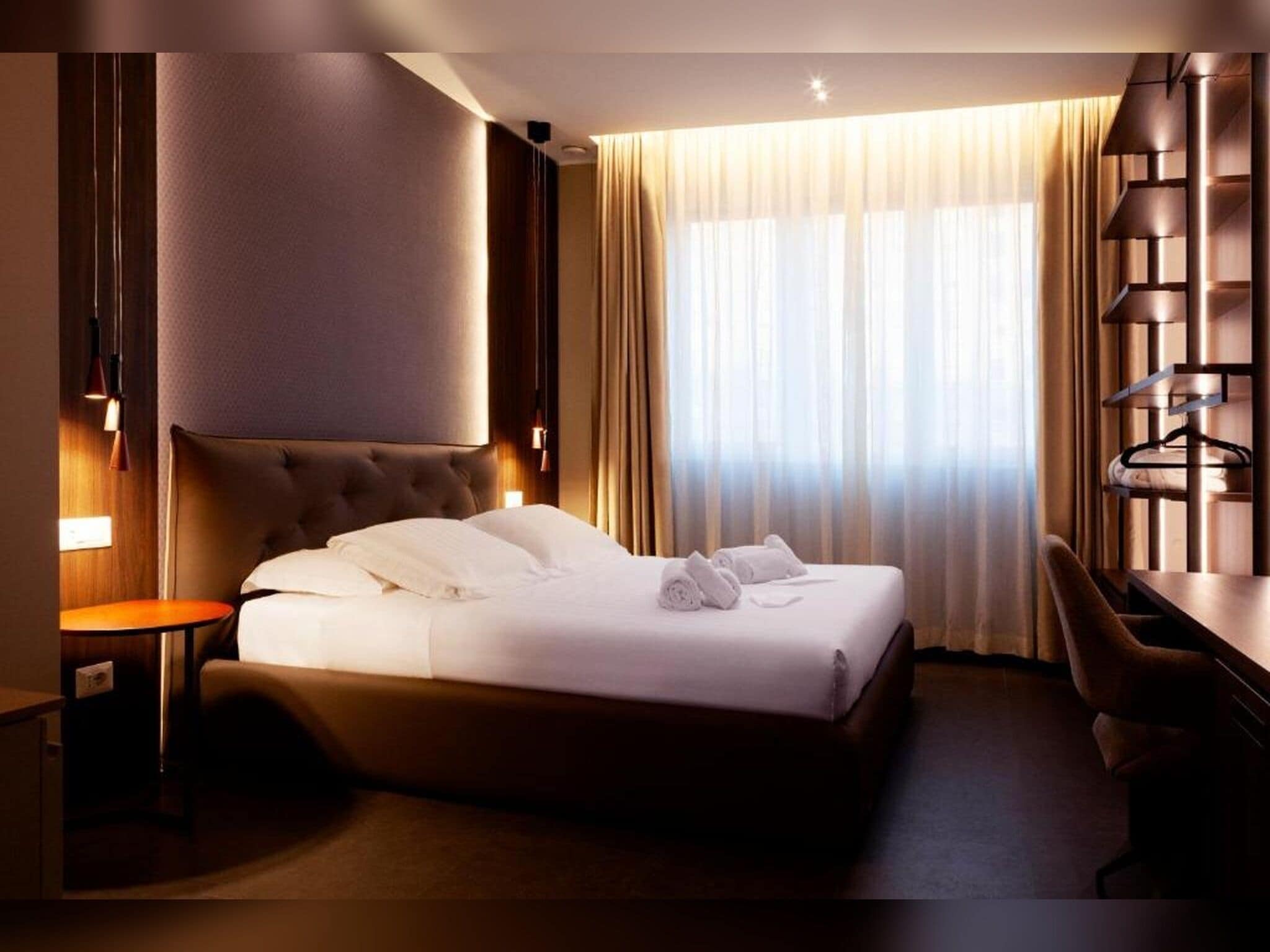 Une chambre d’hôtel avec un grand lit, un bureau et une chaise.