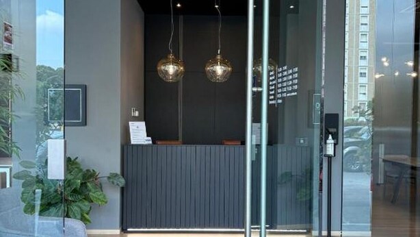 A reception area with a glass partition, a reception desk, and two hanging spherical light fixtures. - PRESTIGE ROOM Luxury Milano  (Milan)