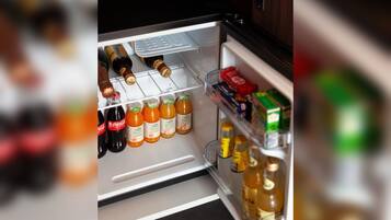 Un refrigerador abierto con varias bebidas y condimentos.