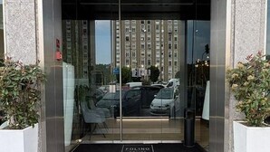 A modern building entrance with a glass door, a black mat, and a sign that reads 'FOLINO'. - PRESTIGE ROOM Luxury Milano  (Milan)