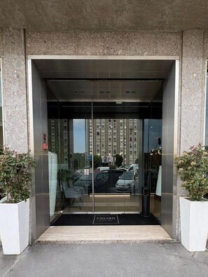 A modern building entrance with a glass door, a black mat, and a sign that reads 'FOLINO'. - PRESTIGE ROOM Luxury Milano  (Milan)