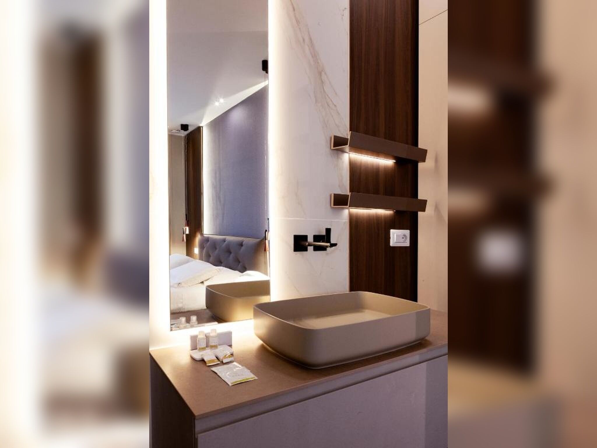 Un baño moderno con un espejo grande, un lavamanos rectangular y un tocador de madera.