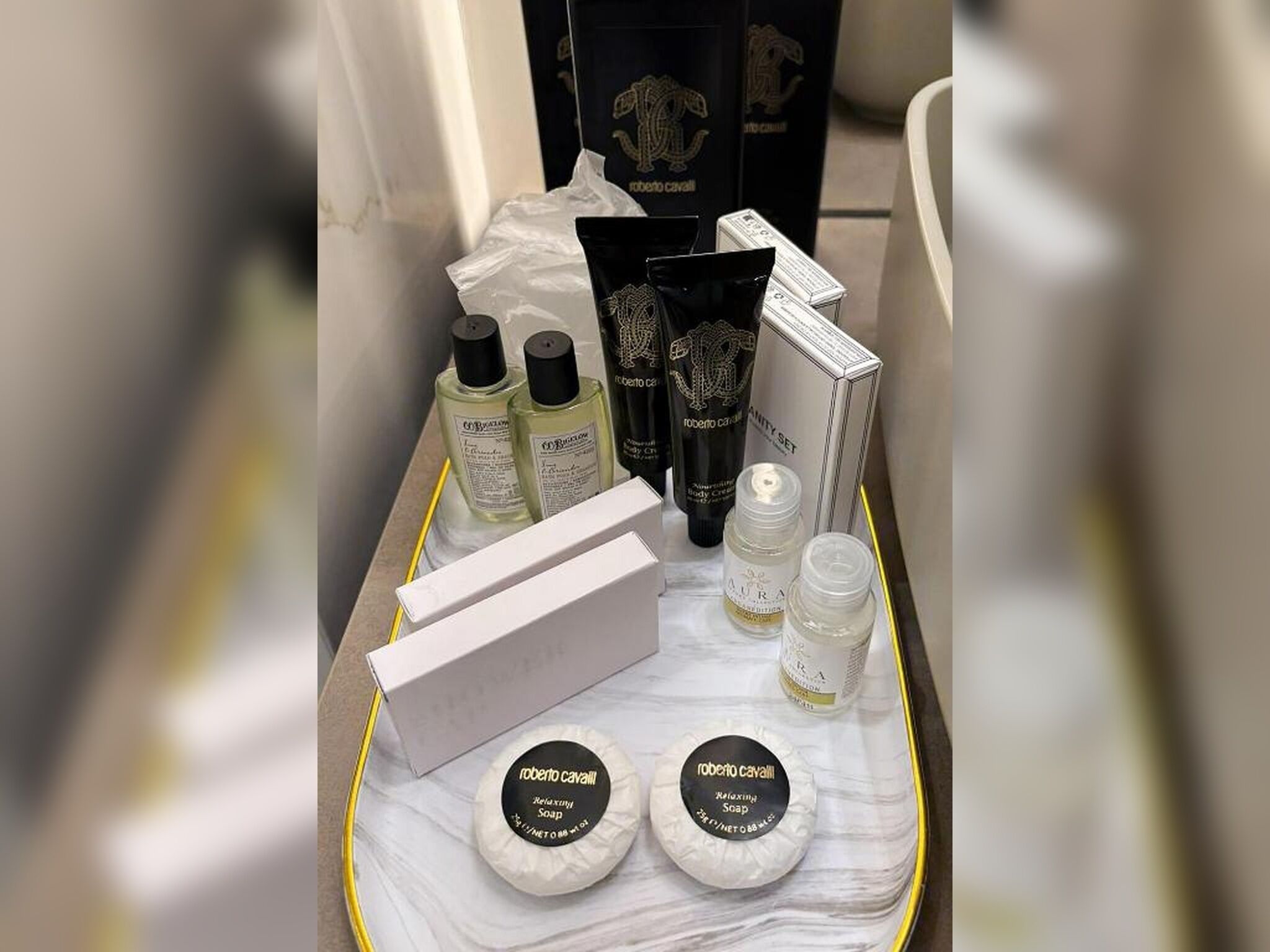 A tray with various toiletries including body care products, a box, and a set of soap bars.
