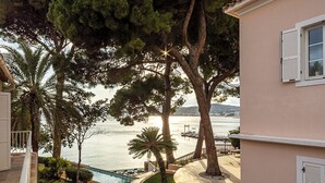 Una propiedad residencial con piscina, una escalera que lleva a una terraza y vista al mar.