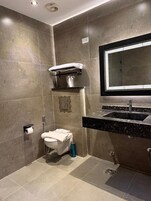 A bathroom with a toilet, sink, and mirror.