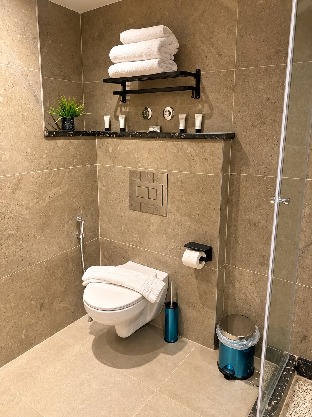 Une salle de bain moderne équipée de toilettes, d’une douche et d’un espace de douche vitré.