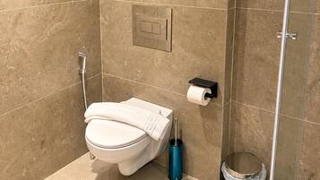 Une salle de bain moderne équipée de toilettes, d’une douche et d’un espace de douche vitré.