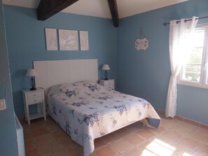 A bedroom with a bed, two bedside tables, a window with curtains, and three wall-mounted artworks. - COTTAGE LES OLIVIERS AT COTIGNAC (Cotignac)