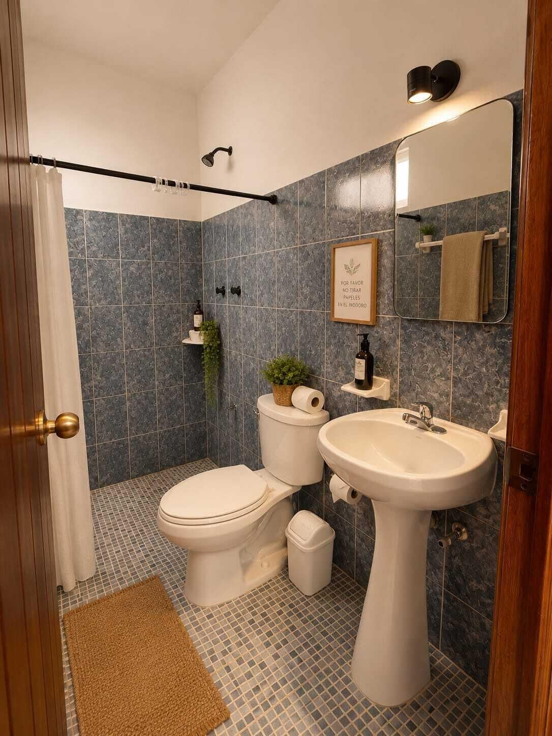Un baño con inodoro, lavamanos, ducha y espejo.