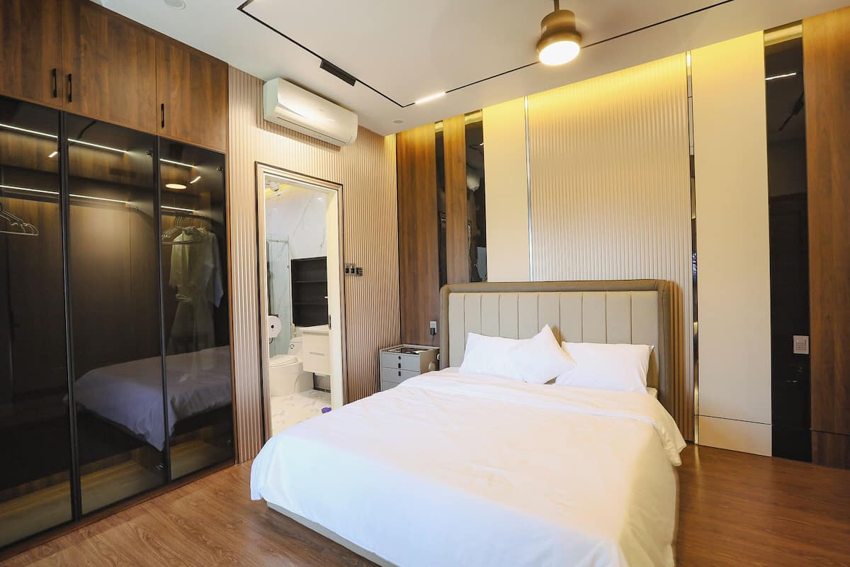 Ein modernes Schlafzimmer mit Bett, Kleiderschrank und begehbarem Kleiderschrank.