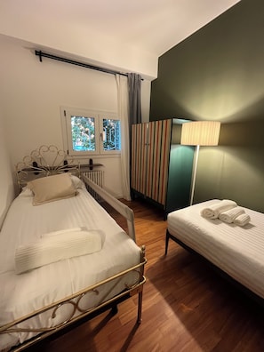 A bedroom with a bed, a bedside table, a lamp, a window, and a radiator. - Casa Barbara, a place where you can feel at home (Sant'Agostino)