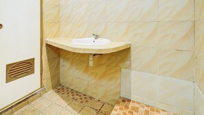 A bathroom with a sink, tiled walls, and patterned floor. - Family Luxury Suite W/free Wifi and Parking (Wiradesa)