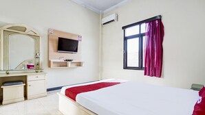 A hotel room with a bed, a TV mounted on the wall, a desk, and a window with curtains. - Family Luxury Suite W/free Wifi and Parking (Wiradesa)