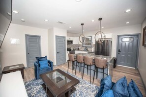 A modern kitchen with a central island, bar stools, and pendant lighting. - Modern 2 bedroom APT 4 bed min FROM  Dawnsonville (Dawsonville)