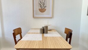 A dining table with chairs, a framed artwork on the wall, and a small decorative item on the table. - Sechser in Münster Roxel—10 minutes from the UKM (Münster)