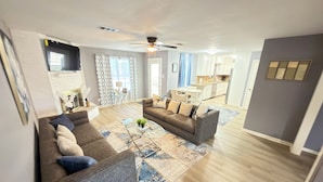 A modern living room with a sofa, coffee table, and patterned rug. - Private 3BR Pool Retreat Near Houston (Deer Park)