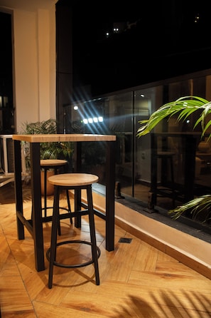 A modern interior with a wooden floor, a glass partition, and a plant. - LE DANORE VIP APPART hotel (Yaoundé)