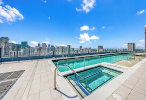 Piscina en la azotea con agua cristalina y vistas a un horizonte urbano.